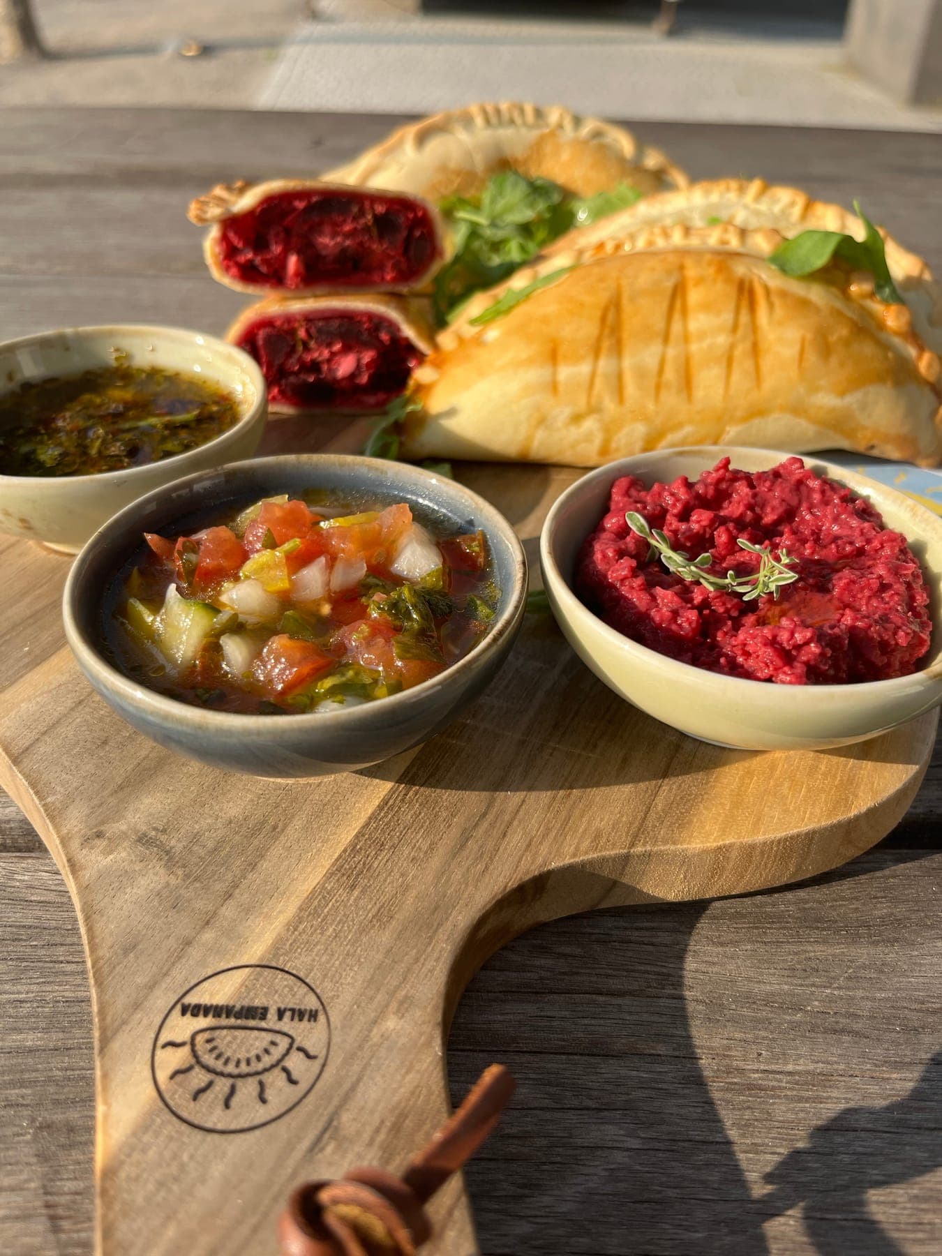 Empanadas mit Dips auf einem Holzbrett
